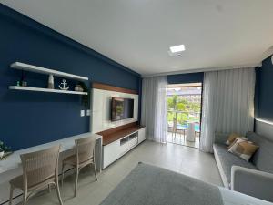 a living room with a blue accent wall at Flat com vista linda Eco Resort in Tamandaré