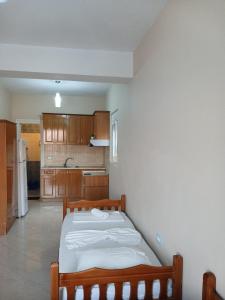 a bedroom with a bed and a kitchen at RAHI Rooms in Gjilek