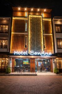 a hotel sign in front of a building at night at Hotel Sanrina Kuta Bali in Kuta