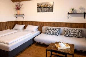 two beds in a room with a table at A+R Pension in Pilsen