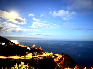 a view of a town on a mountain at night at Sky & Ocean in Calheta