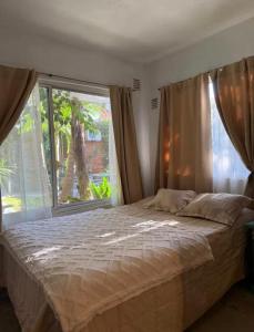 a bedroom with a bed and a large window at Garden! in Villa Ballester
