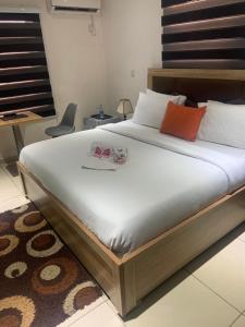 a bedroom with a large bed with orange and white pillows at Trendy Inn limited in Lagos