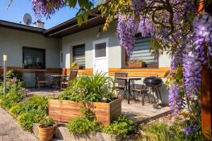 a patio with a table and chairs and purple flowers at A+R Pension in Pilsen
