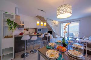 a kitchen and living room with a table and chairs at Como Lake Modern Apartament Ulivi in Mezzegra
