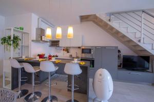 a kitchen with a kitchen island with bar stools at Como Lake Modern Apartament Ulivi in Mezzegra +19 photos