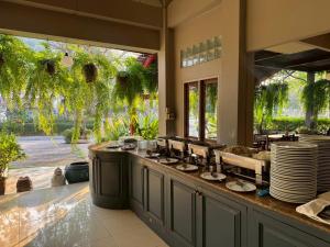 a kitchen with a counter with plates on it at Sun Hotel in Phetchaburi