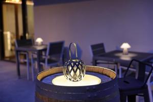 a vase sitting on top of a barrel with tables and chairs at Torre de Quintana in Suances