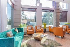 a lobby with a couch and chairs and a table at Sandman Signature Surrey-Guildford Suites in Surrey