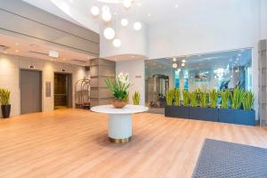 a lobby with a table with flowers on it at Sandman Signature Surrey-Guildford Suites in Surrey