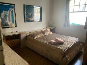 a bedroom with a bed with two pink shoes on it at Casa completa com vaga de garagem 2 quartos in Campinas
