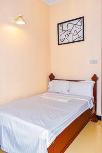 ein Bett in einem Zimmer mit einem Bild an der Wand in der Unterkunft Jackpot Inn in Mbweni