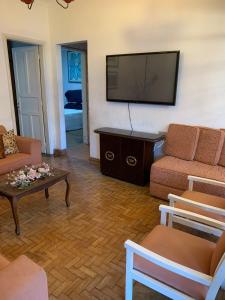 a living room with a couch and a tv at Casa completa com vaga de garagem 2 quartos in Campinas