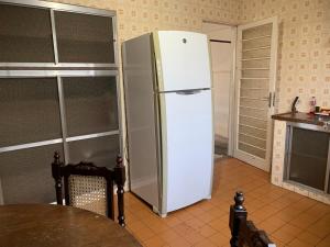a white refrigerator in a kitchen with a table at Casa completa com vaga de garagem 2 quartos in Campinas +7 photos