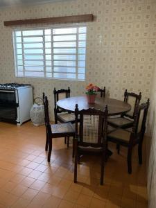 a dining room with a table and chairs and a microwave at Casa completa com vaga de garagem 2 quartos in Campinas
