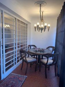 a dining room with a table and chairs and a chandelier at Casa completa com vaga de garagem 2 quartos in Campinas