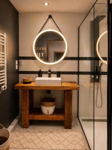 a bathroom with a sink and a mirror at Maisonnette Cosy in La Llagonne