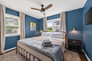 a bedroom with blue walls and a bed with a fan at Chic Home with Huge Grassy Yard 7 mins to Arrowhead Stadium in Independence