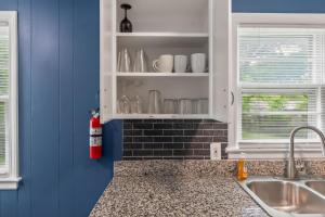 a kitchen with blue walls and a red fire extinguisher at Chic Home with Huge Grassy Yard 7 mins to Arrowhead Stadium in Independence +40 photos