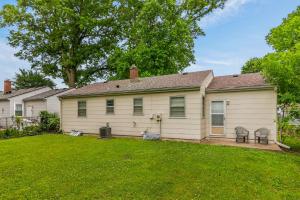 a white house with a yard with chairs at Chic Home with Huge Grassy Yard 7 mins to Arrowhead Stadium in Independence
