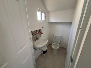 ein kleines Badezimmer mit Toilette und Waschbecken in der Unterkunft Casa Manu in Mérida