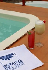 a drink on a table next to a swimming pool at Villas y Suites Paraiso del Sur in Cuernavaca