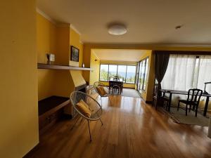 a living room with yellow walls and a table and chairs at Machico View in Machico