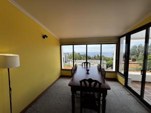 a dining room with a table and chairs and windows at Machico View in Machico