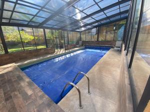 a large swimming pool in a building with a glass ceiling at El Apapacho in Cuernavaca