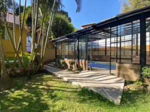 a glass house with a pool in a yard at El Apapacho in Cuernavaca