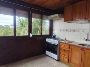 a kitchen with a stove top oven next to windows at Las palmas in Costa Azul