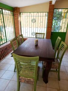 a wooden table and chairs in a room with stained glass at El Apapacho in Cuernavaca