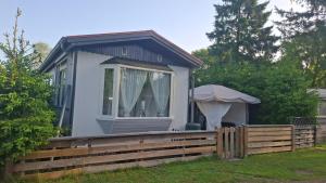 a tiny house with a porch and a fence at Chalet Lieke Nr386 in Eext