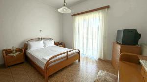 a bedroom with a bed with a television and a dresser at Fokianos Gate in Peletá