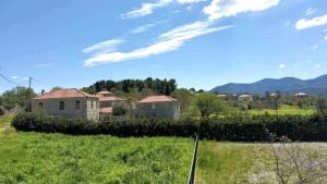 a house in a field with mountains in the background at Fokianos Gate in Peletá
