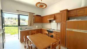 a kitchen with wooden cabinets and a wooden table at Fokianos Gate in Peletá