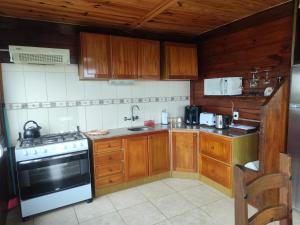 a kitchen with wooden cabinets and a stove at Las palmas in Costa Azul