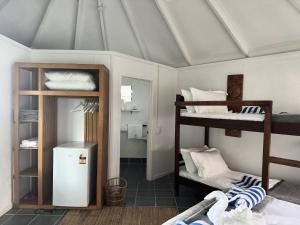 a room with two bunk beds and a refrigerator at Coral Quays Resort in Luganville