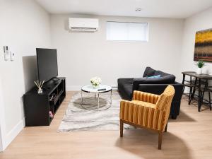 a living room with a black couch and a table at Quiet Haven - One-Bedroom Suite in Riverview