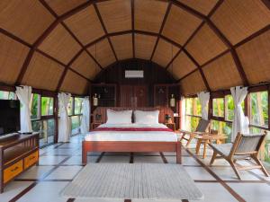 a bedroom with a bed and a tv and windows at Saung Komando Ciwidey in Winducina