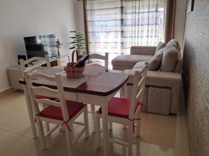 a living room with a table and chairs and a couch at Os Robalos in Moura