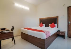 a bedroom with a bed and a desk and a bed sidx sidx sidx at Super Hotel O Gokul Grand Near SR Nagar Police Station in Hyderabad +35 photos
