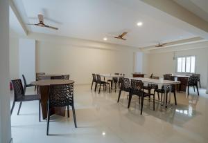 a dining room with tables and chairs in a room at Super Hotel O Gokul Grand Near SR Nagar Police Station in Hyderabad