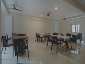 a dining room with tables and chairs in a room at Super Hotel O Gokul Grand Near SR Nagar Police Station in Hyderabad