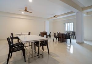 a dining room with tables and chairs and a ceiling at Super Hotel O Gokul Grand Near SR Nagar Police Station in Hyderabad