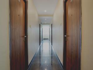 a hallway with two wooden doors and a long corridor at Super Hotel O Gokul Grand Near SR Nagar Police Station in Hyderabad
