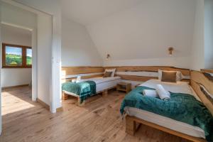 two beds in a room with wooden floors at Biała Owca in Biały Dunajec