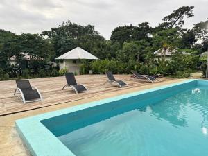 a swimming pool with two lounge chairs next to a wooden deck at Coral Quays Resort in Luganville