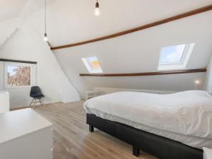 a bedroom with a bed and a desk and windows at De Loft in Veurne