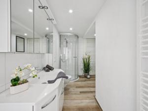 a white bathroom with a tub and a sink at Modern apartments harz I in Elbingerode +16 photos